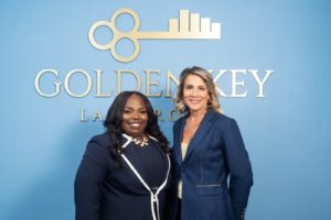 Pinellas county divorce attorneys posing in front of Golden Key Law Group logo