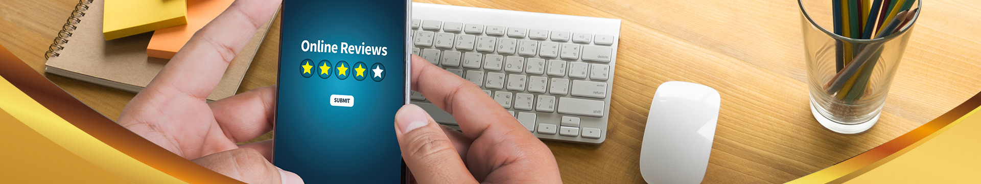 Male hands hold a phone over the a smooth silver and white keyboard with an all white mouse