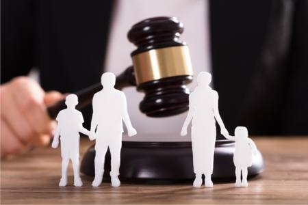 Figurines of a separated family, next to a gavel