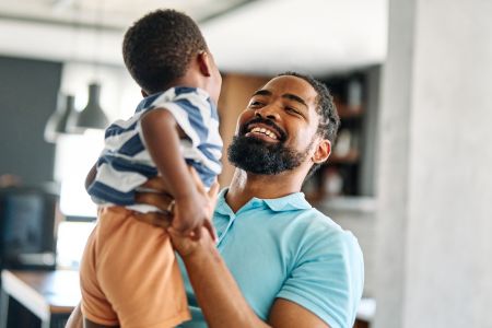 Father holding a child and smiling