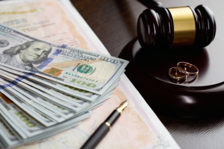 A stack of money sitting next to a gavel